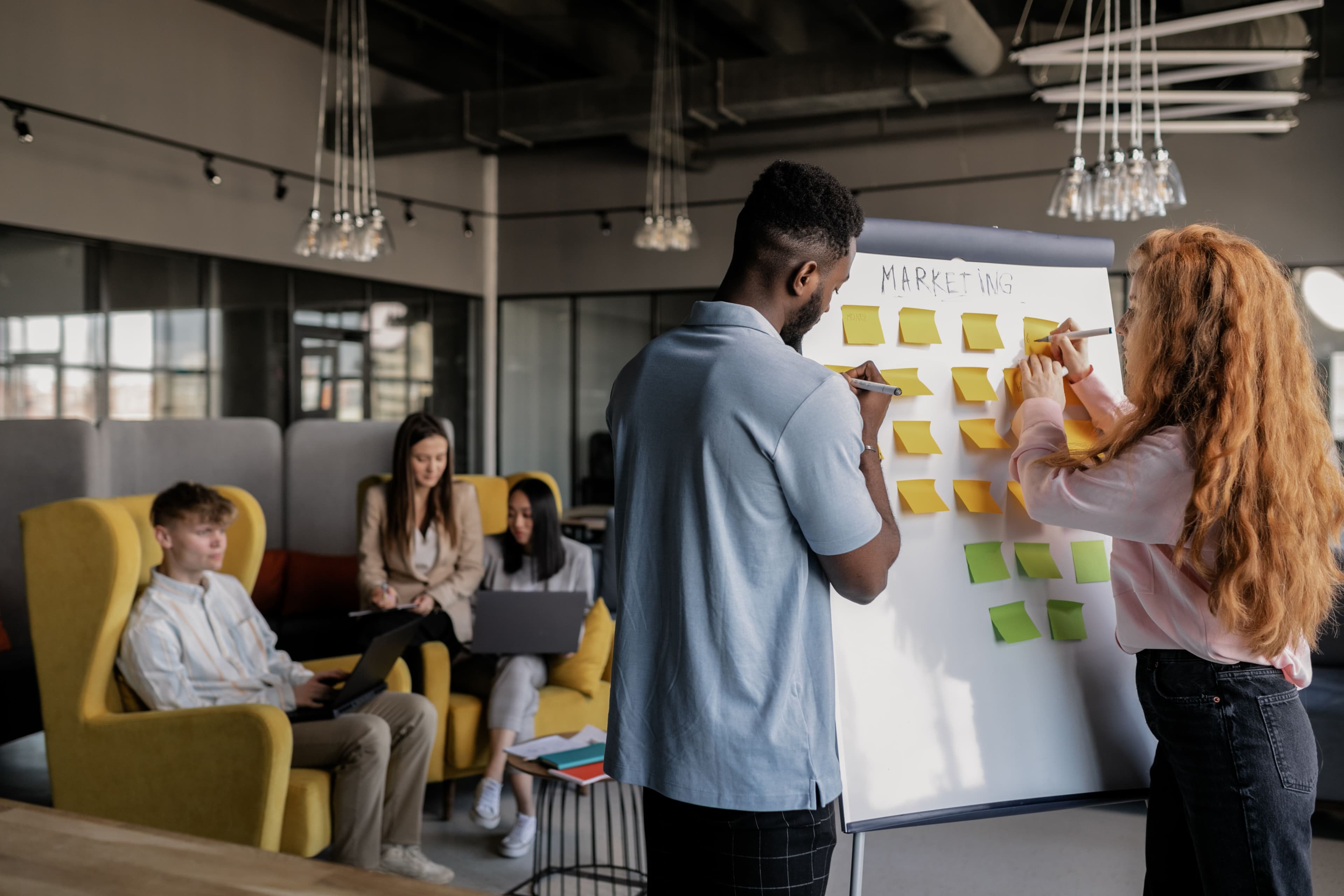 People arranging notes on a workshop board during a planning exercise
