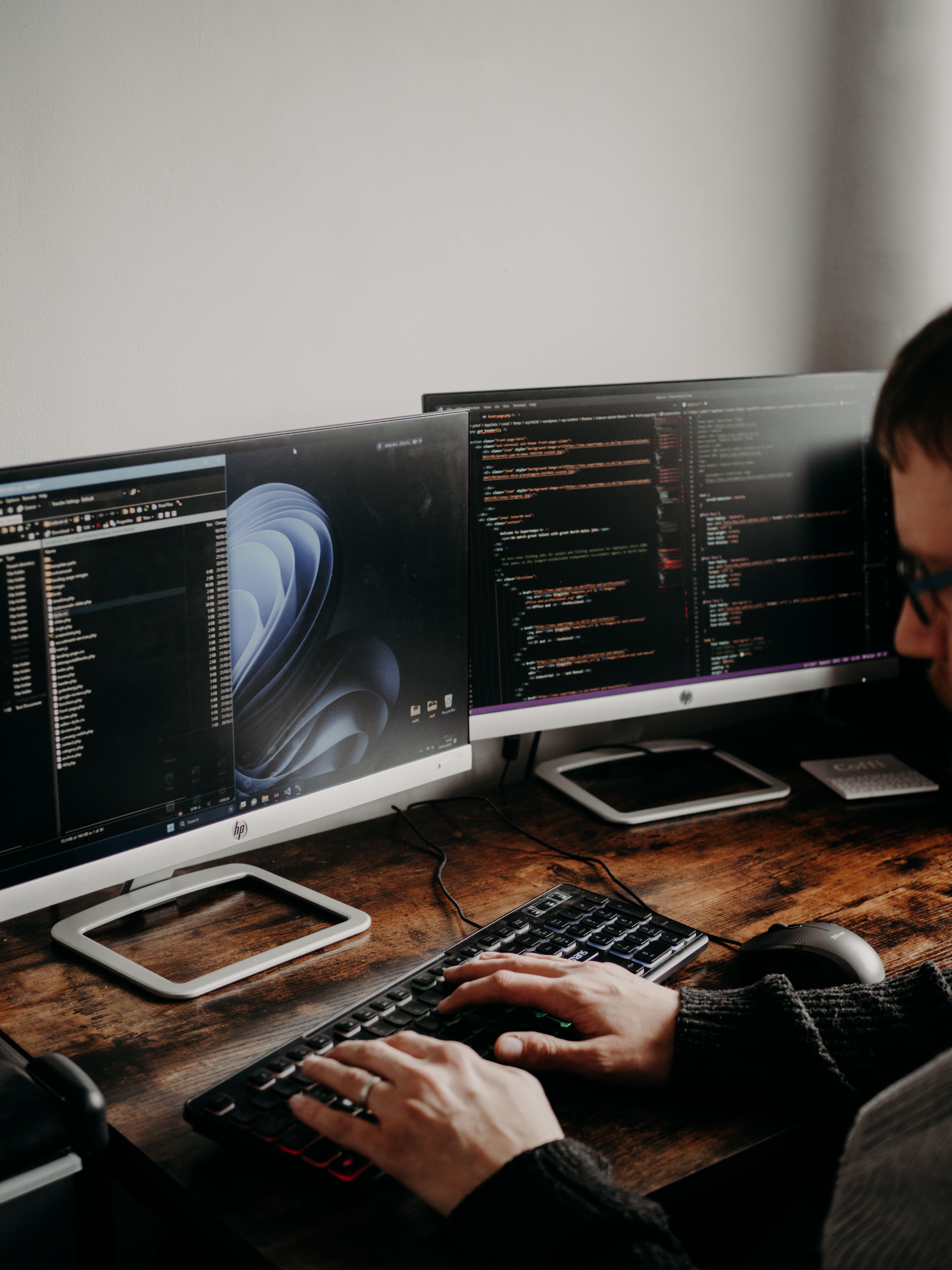 Developer working across multiple monitors displaying website code